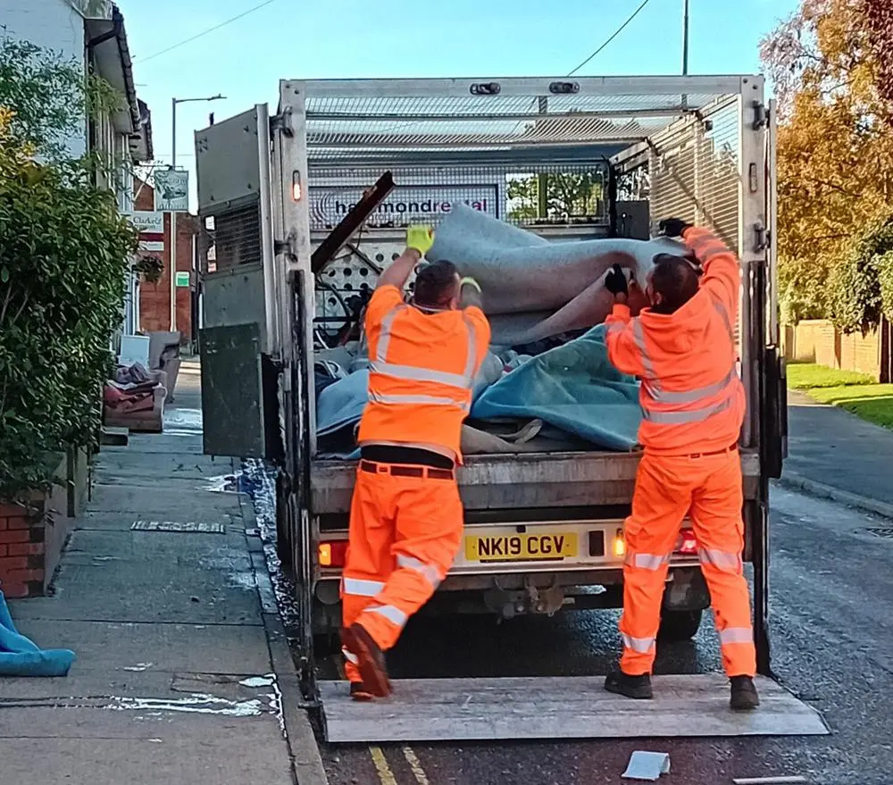 Council operatives loading carpet into lorry
