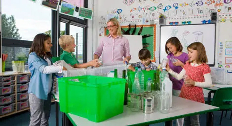 Teacher and pupils sorting through recycling. 