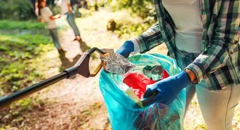 Person holding a bag with litter in. 