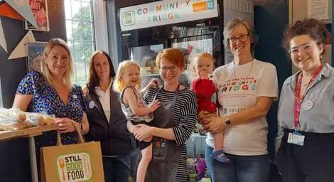 A group of people at a community fridge. 